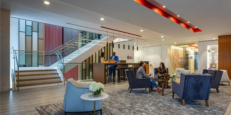 Modern office lobby with seating and stairs.