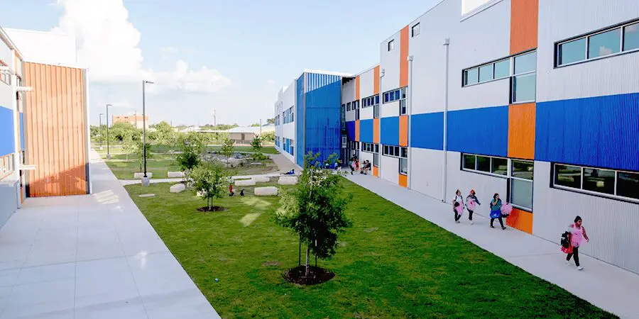 Colorful school building with students outside.